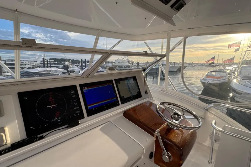  Yacht Photos Pics Helm of 2013 Hatteras GT54 yacht with navigation screens, overlooking marina at sunset.