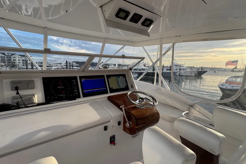  Yacht Photos Pics Helm of 2013 Hatteras GT54 yacht with navigation screens, overlooking marina at sunset.
