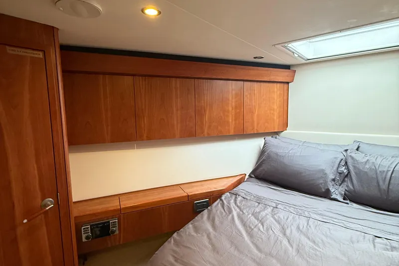  Yacht Photos Pics Luxurious cabin interior of 2013 Hatteras GT54 yacht with wood paneling and cozy bedding.