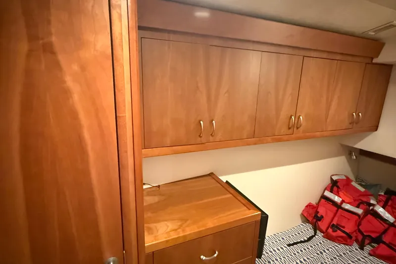  Yacht Photos Pics Wooden cabinetry and storage in 2013 Hatteras GT54 interior, with red life jackets visible.
