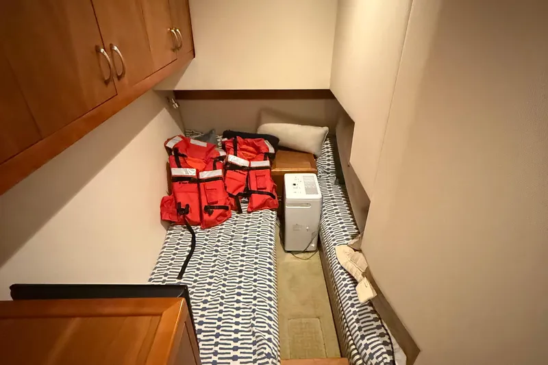  Yacht Photos Pics 2013 Hatteras GT54 cabin with life jackets and patterned bedding.
