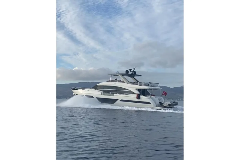  Yacht Photos Pics Luxurious 2020 Princess Y78 yacht cruising on open water under a cloudy sky.