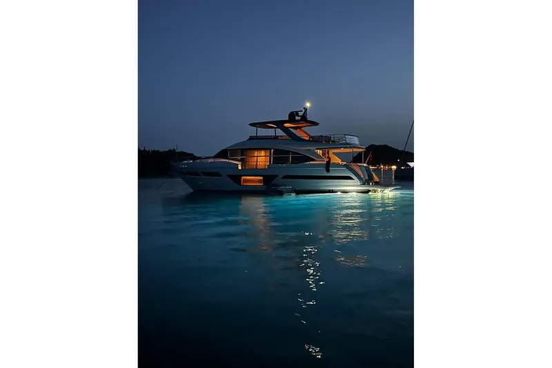  Yacht Photos Pics Luxurious 2020 Princess Y78 yacht illuminated at night on calm waters.
