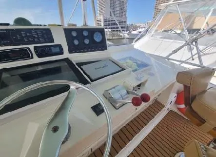 Dry-hydro Yacht Photos Pics 1990 Viking Convertible yacht helm with navigation instruments and steering wheel, docked in a marina.