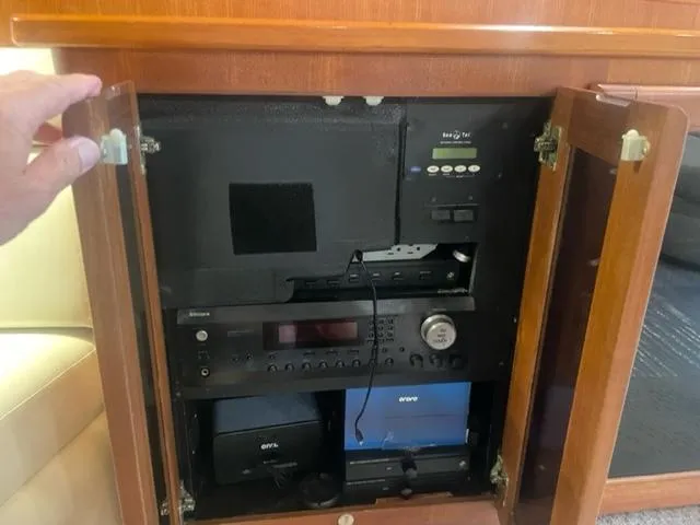 Dry-hydro Yacht Photos Pics 1990 Viking Convertible audio system cabinet with electronic equipment and wooden doors open.