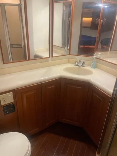 Dry-hydro Yacht Photos Pics 1990 Viking Convertible yacht bathroom with wooden cabinets and corner sink.