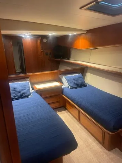 Dry-hydro Yacht Photos Pics 1990 Viking Convertible yacht cabin with twin beds, wooden interior, and blue bedding.