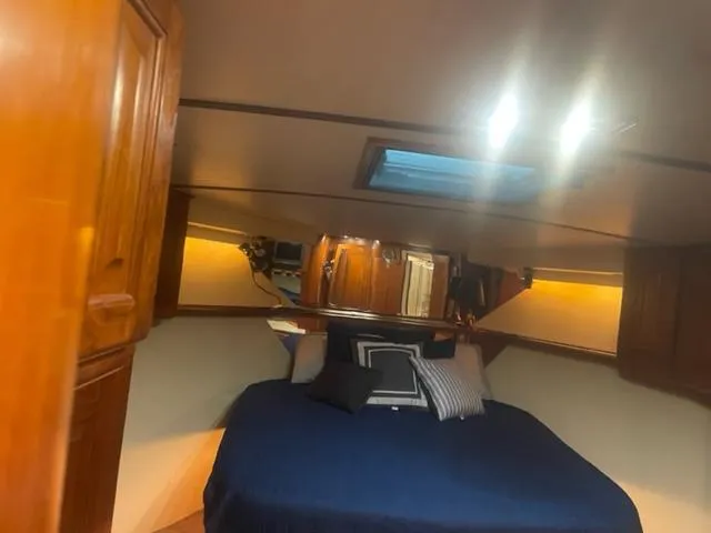 Dry-hydro Yacht Photos Pics Cozy cabin interior of 1990 Viking Convertible boat with blue bedding and wooden accents.