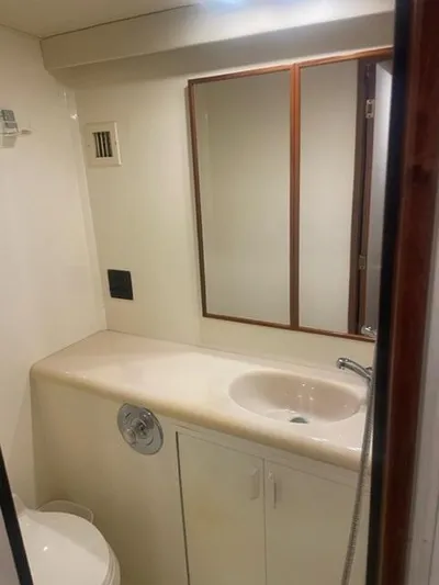 Dry-hydro Yacht Photos Pics 1990 Viking Convertible yacht bathroom with sink, mirror, and storage cabinet.