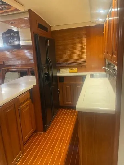 Dry-hydro Yacht Photos Pics 1990 Viking Convertible yacht kitchen with wooden cabinets and modern appliances.