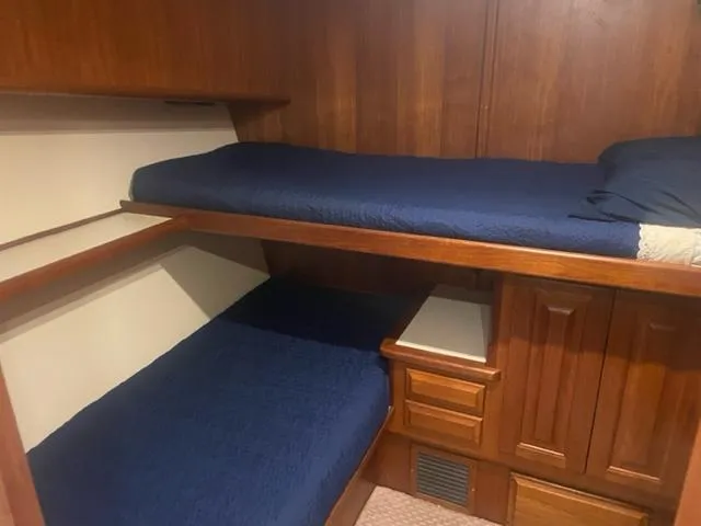 Dry-hydro Yacht Photos Pics 1990 Viking Convertible cabin with wooden bunk beds and blue bedding.