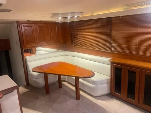Dry-hydro Yacht Photos Pics Luxurious interior of a 1990 Viking Convertible yacht with wooden furnishings and white seating.
