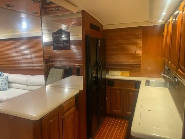 Dry-hydro Yacht Photos Pics Interior of a 1990 Viking Convertible yacht with wooden cabinetry and modern kitchen amenities.
