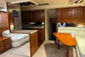 Dry-hydro Yacht Photos Pics 1990 Viking Convertible yacht interior with wooden cabinetry and white seating area.