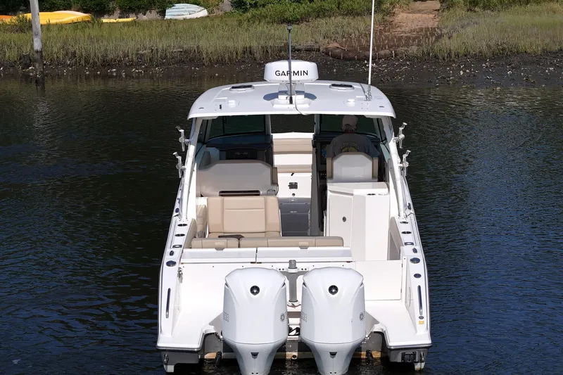  Yacht Photos Pics 2018 Pursuit DC 295 Dual Console boat on water, rear view with twin engines.