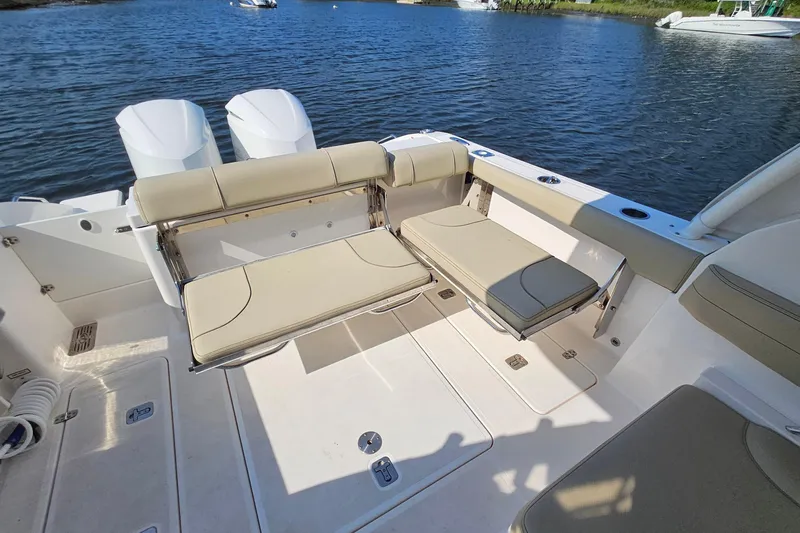  Yacht Photos Pics 2018 Pursuit DC 295 Dual Console boat interior with seating, on calm water.