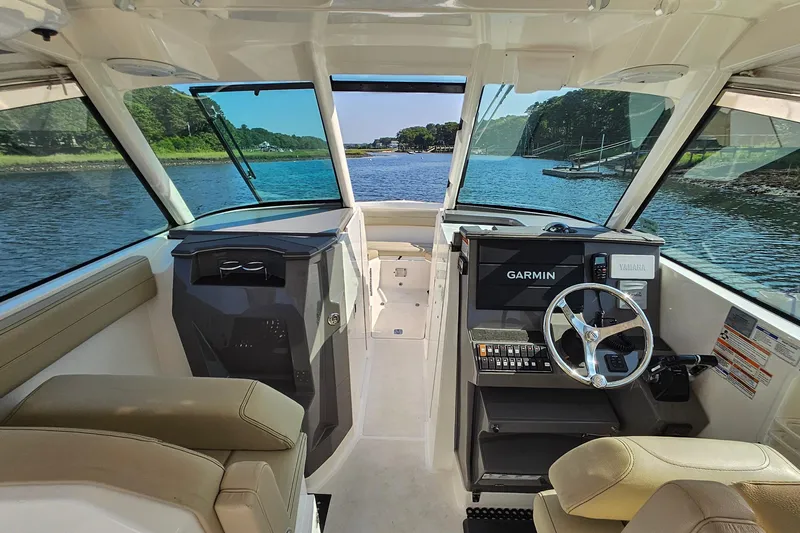  Yacht Photos Pics 2018 Pursuit DC 295 Dual Console interior with Garmin navigation, steering wheel, and scenic water view.