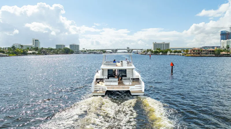 Euphoria Yacht Photos Pics 2024 Leopard 53 Powercat cruising on a sunny day in a scenic waterway.