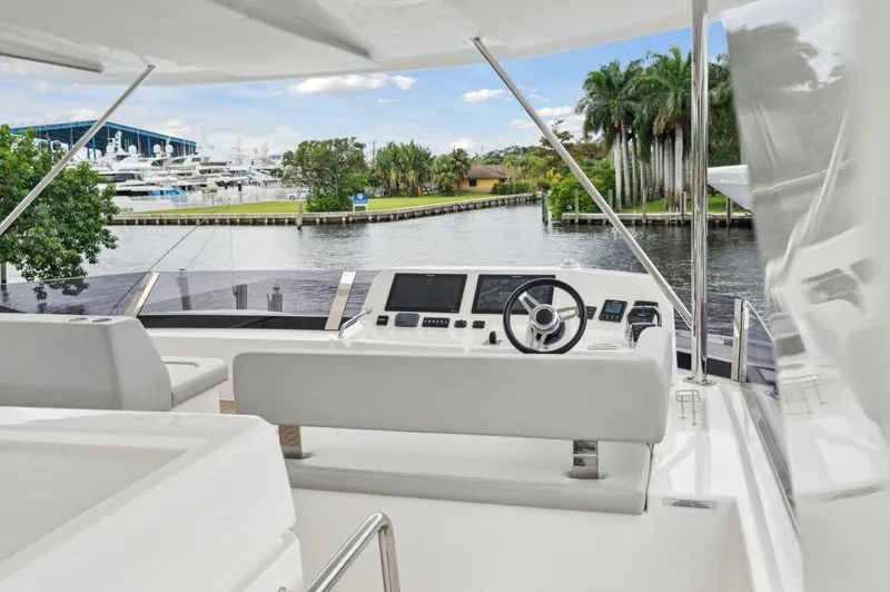 Euphoria Yacht Photos Pics 2024 Leopard 53 Powercat yacht helm with waterfront view and lush greenery.