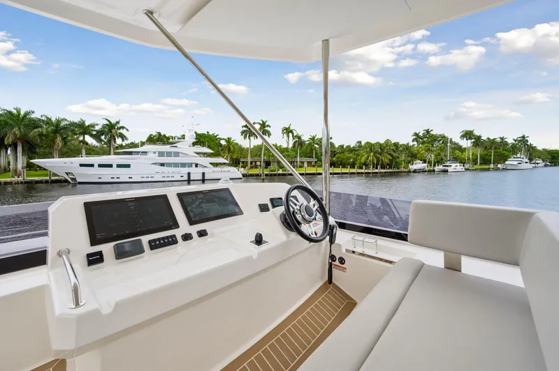 Euphoria Yacht Photos Pics 2024 Leopard 53 Powercat helm with waterfront view and palm trees.