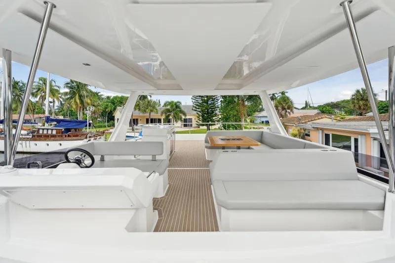 Euphoria Yacht Photos Pics 2024 Leopard 53 Powercat interior with modern seating and steering, docked near palm trees.