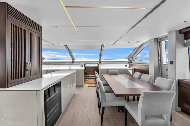 Worth The Wait Yacht Photos Pics Luxurious interior of 2024 Sunseeker Ocean 182 yacht with modern dining area and panoramic windows.