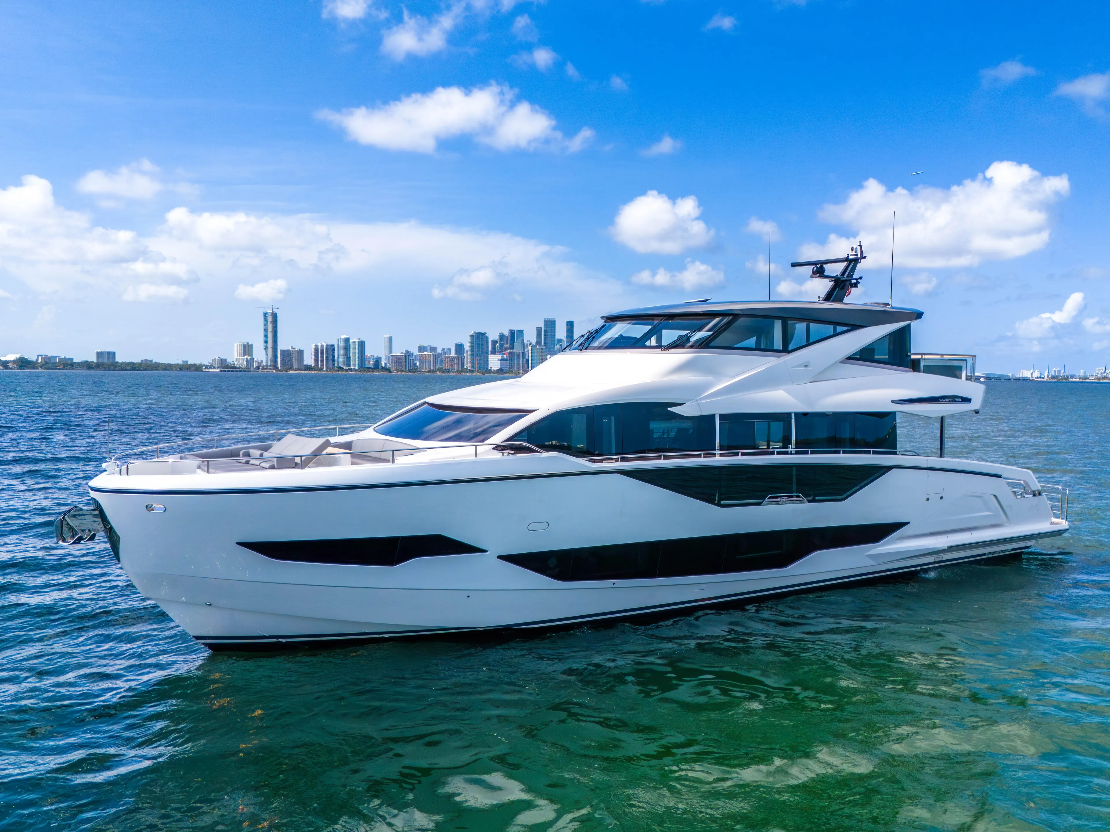 Worth The Wait Yacht Photos Pics 2024 Sunseeker Ocean 182 yacht on water with city skyline in background.