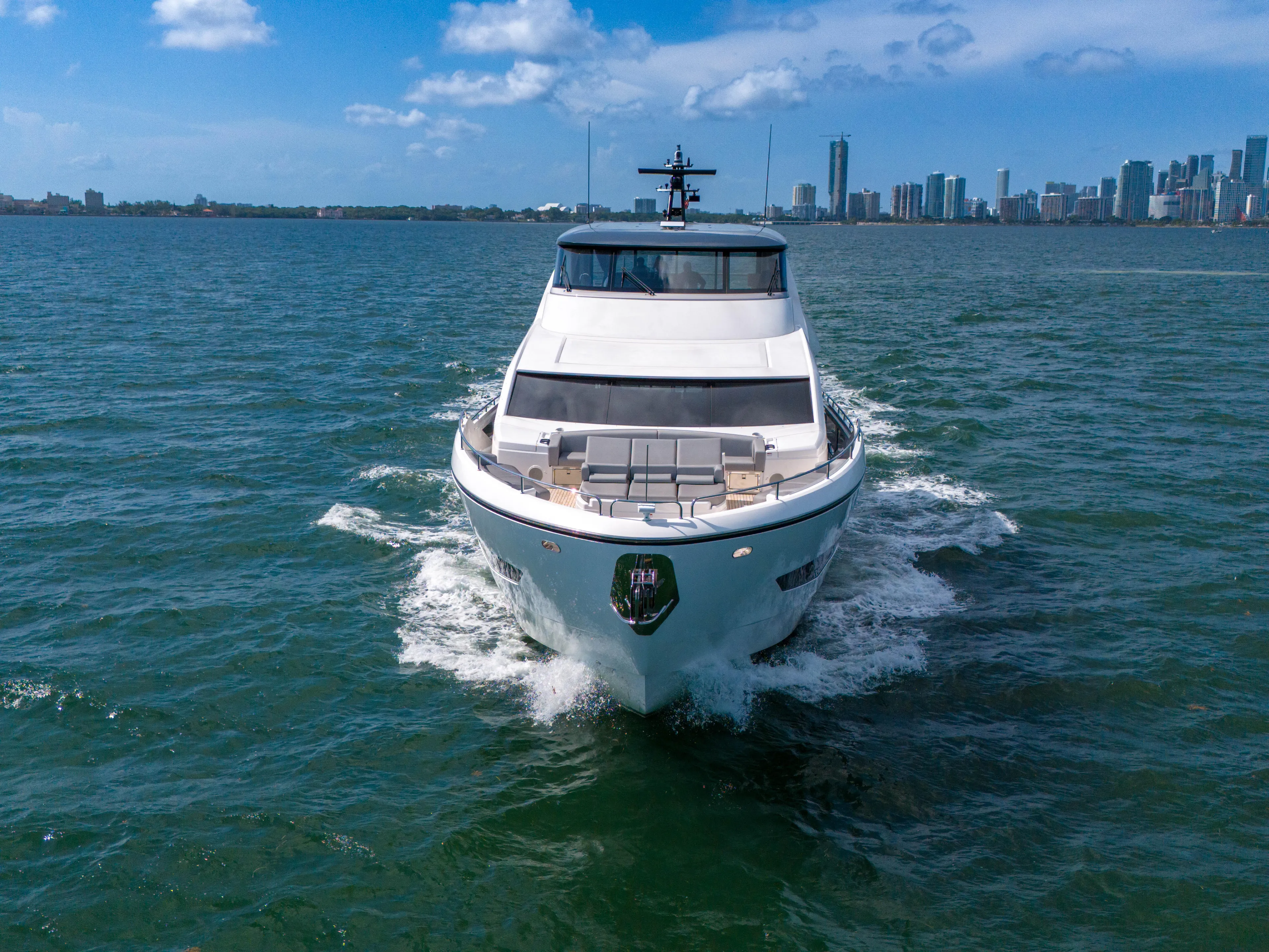 Worth The Wait Yacht Photos Pics 2024 Sunseeker Ocean 182 yacht cruising on open water with city skyline backdrop.
