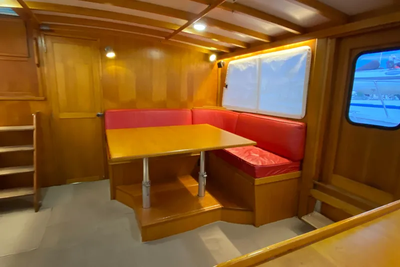 Lord Stanley Yacht Photos Pics 1988 Lyman-Morse Jarvis Newman cruiser interior with wooden paneling and red cushioned seating.