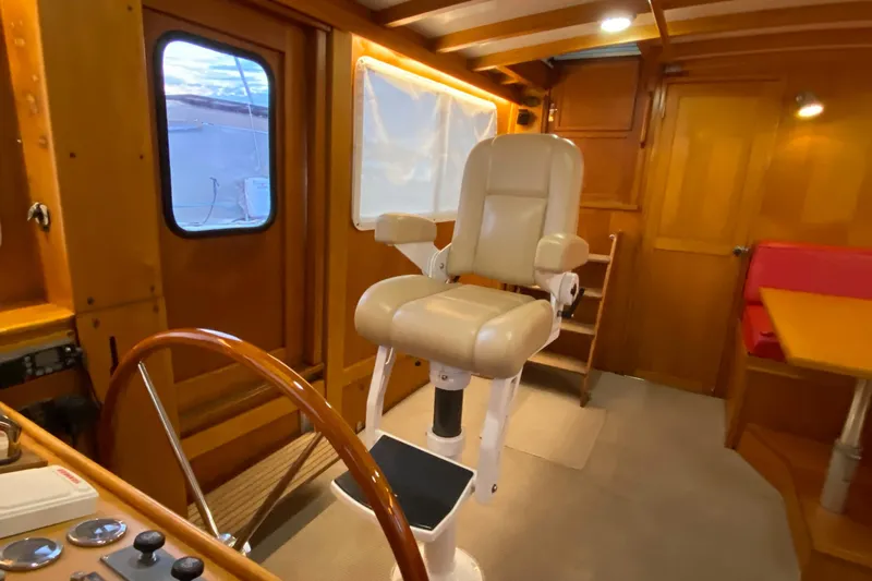 Lord Stanley Yacht Photos Pics 1988 Lyman-Morse Jarvis Newman Lobster Cruiser interior with helm chair and wooden cabin.