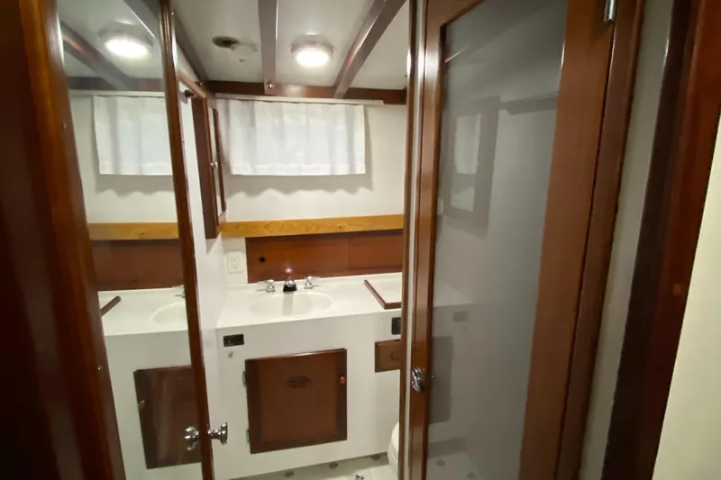 Lord Stanley Yacht Photos Pics 1988 Lyman-Morse Jarvis Newman cruiser bathroom with wood accents and mirrored cabinets.