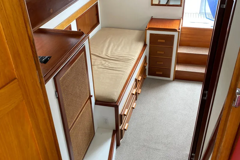 Lord Stanley Yacht Photos Pics 1988 Lyman-Morse Jarvis Newman Lobster Cruiser interior with bed, wooden cabinets, and carpeted floor.