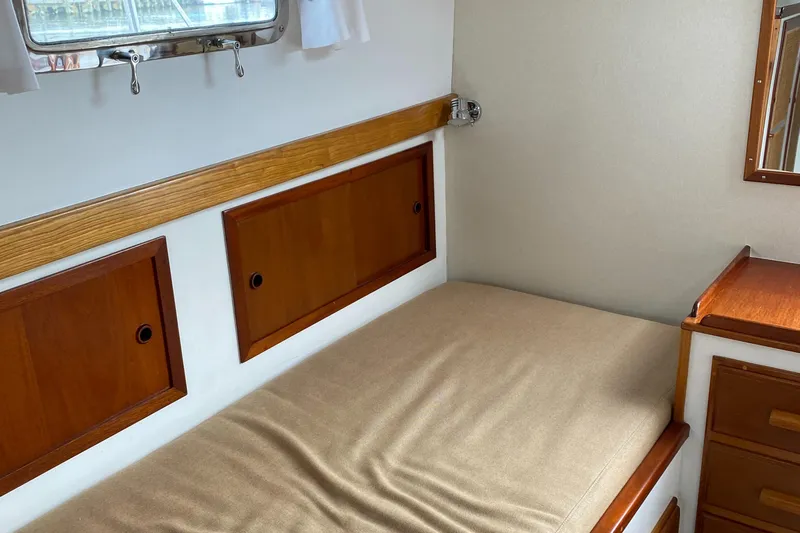 Lord Stanley Yacht Photos Pics 1988 Lyman-Morse Jarvis Newman cruiser interior with wooden cabinetry and cozy bed.