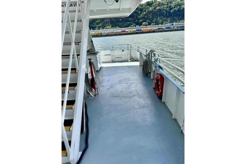 M/v Explorer Yacht Photos Pics Deck of a 2016 Custom Commercial Research Riverboat with safety equipment and scenic river view.