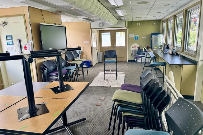 M/v Explorer Yacht Photos Pics Interior of a 2016 Custom Commercial Research Riverboat with stacked chairs and tables.