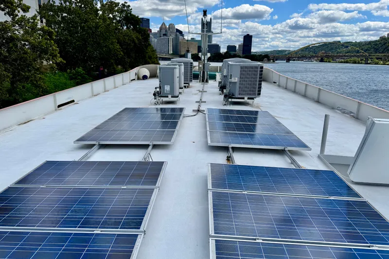 M/v Explorer Yacht Photos Pics Solar panels on a 2016 Custom Commercial Research Riverboat deck, city skyline in background.
