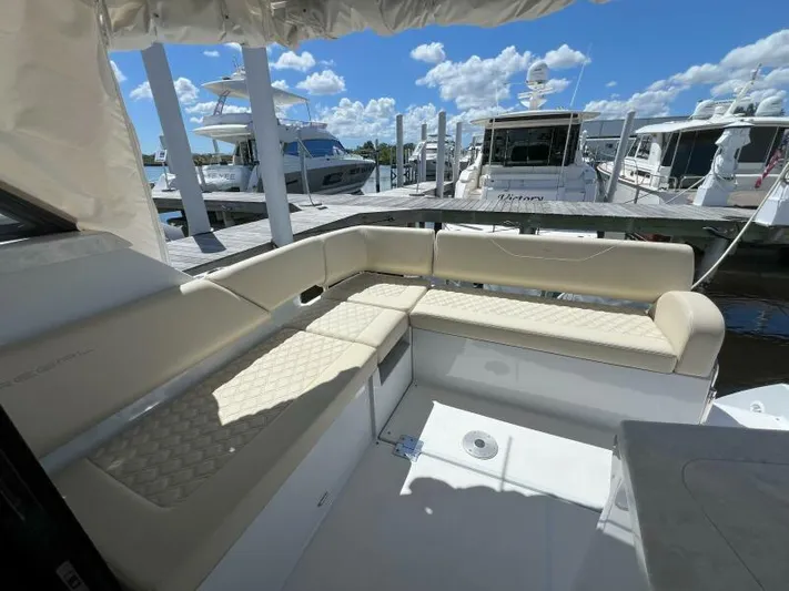Great Expectations Yacht Photos Pics 2020 Regal 38 XO yacht interior with beige seating, docked under a sunny sky.