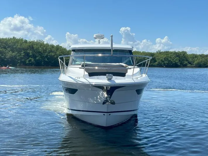 Great Expectations Yacht Photos Pics 2020 Regal 38 XO yacht cruising on a sunny day, surrounded by lush greenery.