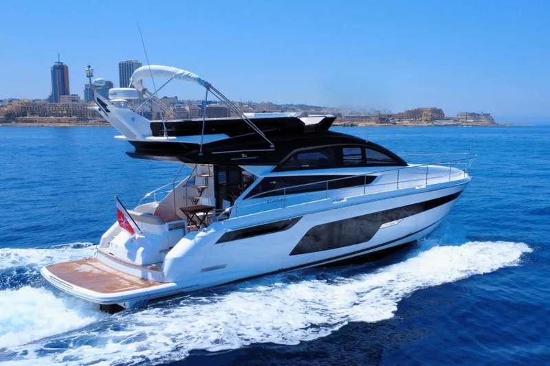 Waypoint Yacht Photos Pics 2024 Fairline Squadron 50 yacht cruising on blue ocean near city skyline.