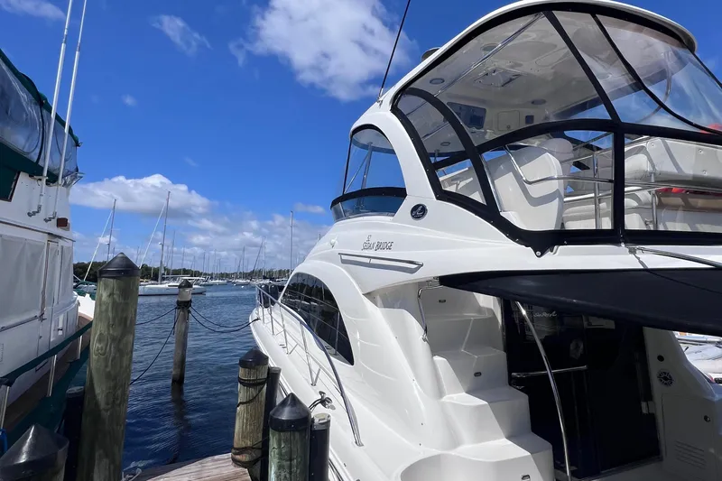  Yacht Photos Pics 2006 Sea Ray 52 Sedan Bridge yacht docked at marina under blue sky.
