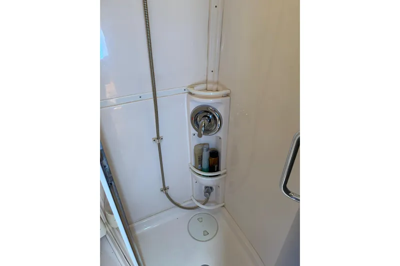 Chapuzon III Yacht Photos Pics Shower area in 2001 Intrepid 377 Walkaround boat with chrome fixtures and storage shelves.