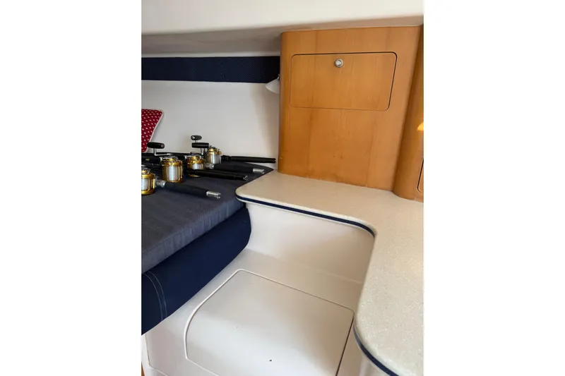 Chapuzon III Yacht Photos Pics Interior of 2001 Intrepid 377 Walkaround boat with fishing rods and wooden cabinetry.