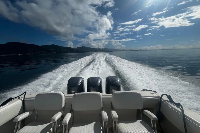 Chapuzon III Yacht Photos Pics 2001 Intrepid 377 Walkaround boat cruising on calm waters under a partly cloudy sky.