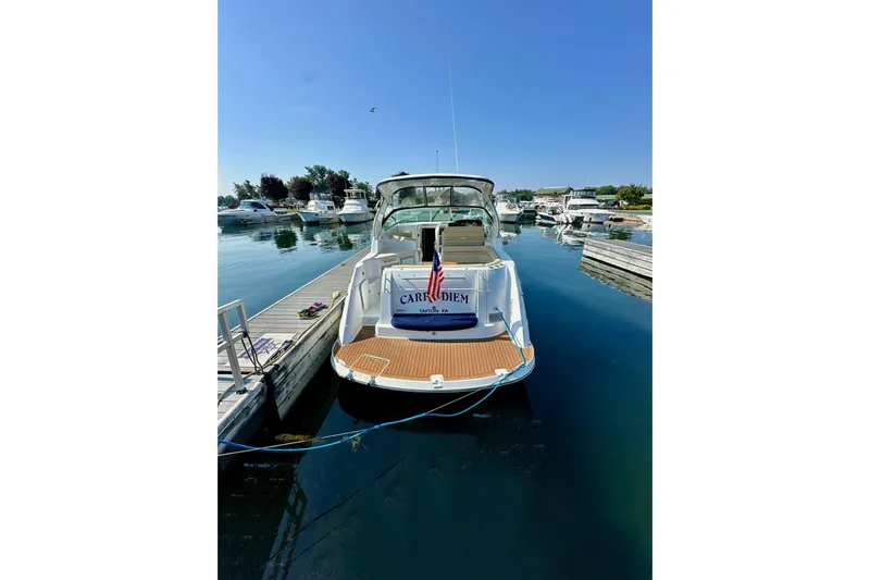 Carpe Diem Yacht Photos Pics 2015 Rinker 340 Express Cruiser docked at marina under clear blue sky.