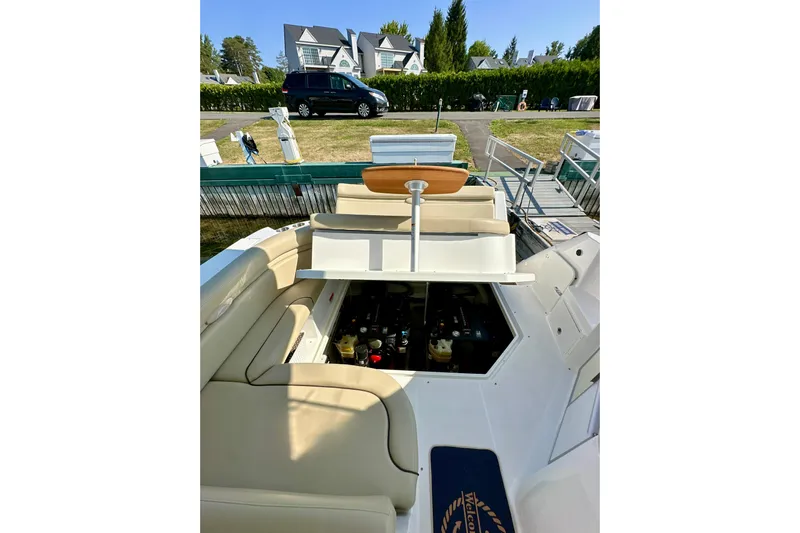 Carpe Diem Yacht Photos Pics 2015 Rinker 340 Express Cruiser interior with open engine compartment, docked near residential area.