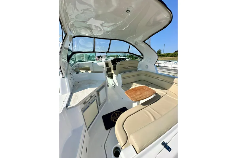 Carpe Diem Yacht Photos Pics 2015 Rinker 340 Express Cruiser interior with beige seating and wooden table.