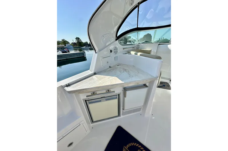 Carpe Diem Yacht Photos Pics 2015 Rinker 340 Express Cruiser interior with kitchenette and seating, docked by the water.