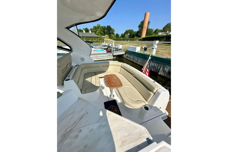 Carpe Diem Yacht Photos Pics 2015 Rinker 340 Express Cruiser interior with seating and table, docked near greenery.