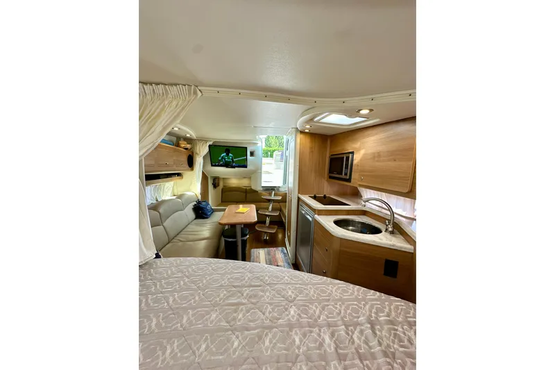 Carpe Diem Yacht Photos Pics 2015 Rinker 340 Express Cruiser interior with kitchen, seating, and TV.