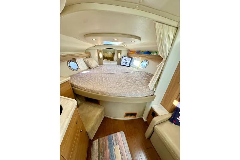 Carpe Diem Yacht Photos Pics 2015 Rinker 340 Express Cruiser cabin interior with cozy bed and wooden furnishings.
